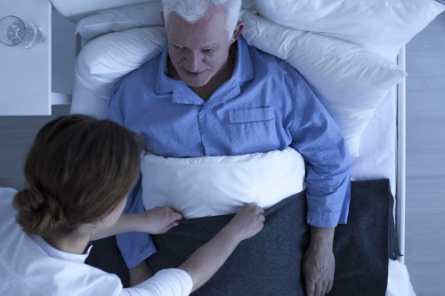 Helping an elderly man going to bed at night
