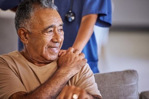 Placing hand over an elderly man sitting down